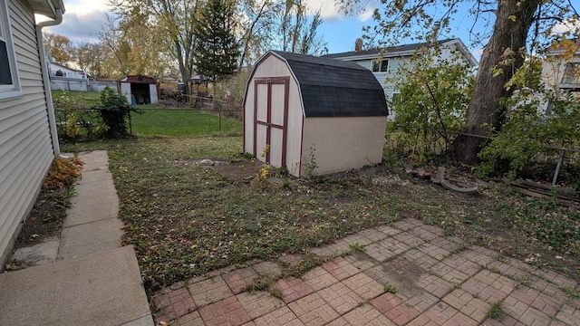 view of yard featuring an outbuilding, a storage unit, and fence