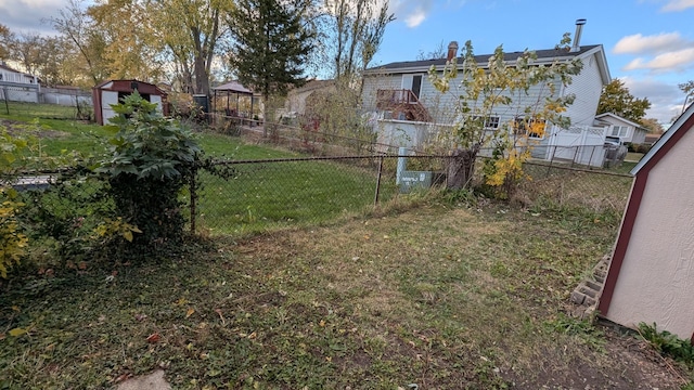 view of yard featuring an outbuilding, a storage unit, and a fenced backyard