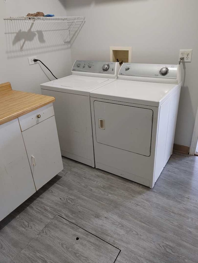 laundry area with light wood-type flooring, washing machine and dryer, and laundry area