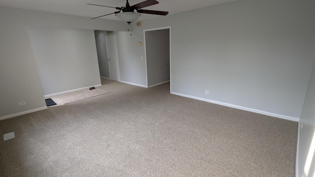 empty room featuring baseboards, carpet floors, and a ceiling fan