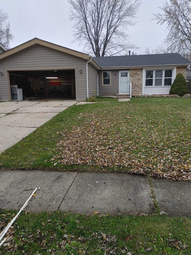 view of front of home featuring entry steps, a front yard, concrete driveway, and a garage