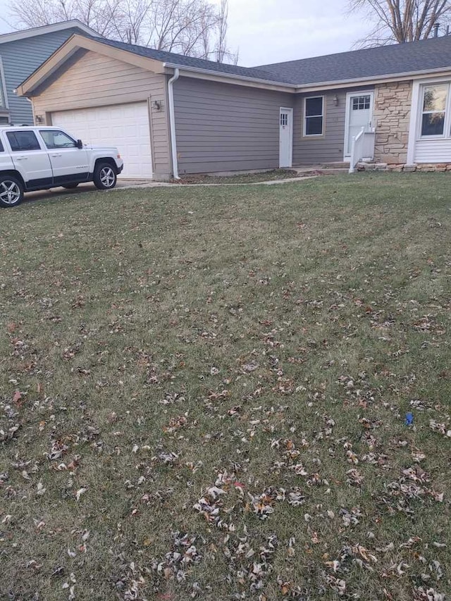 view of front facade with stone siding, a front lawn, and an attached garage