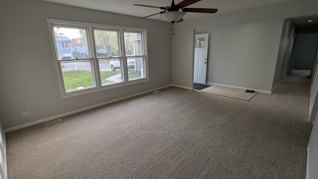 carpeted empty room featuring a ceiling fan, baseboards, and visible vents