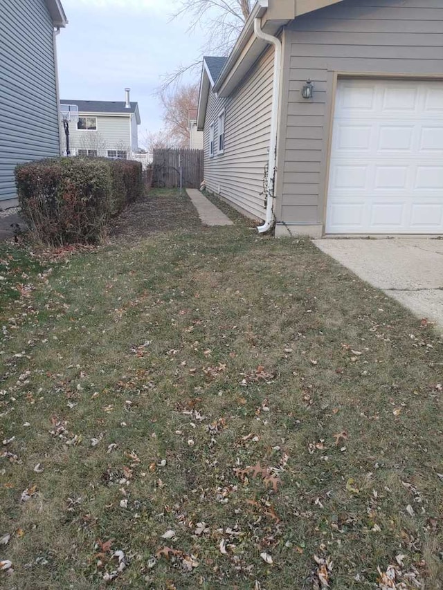 view of yard featuring a garage and fence