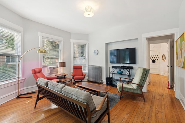 living room featuring radiator, cooling unit, and light wood-type flooring