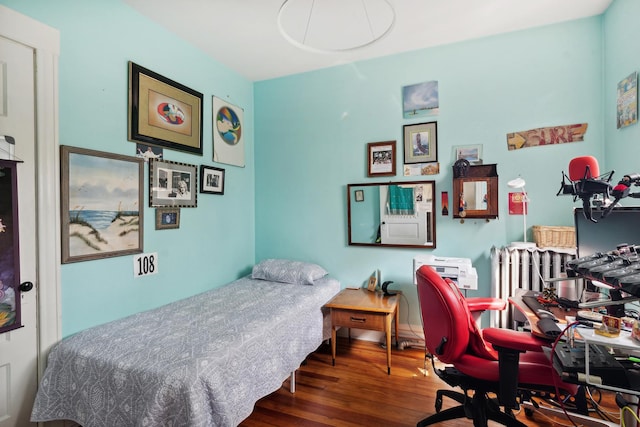 bedroom featuring radiator heating unit and dark wood-type flooring