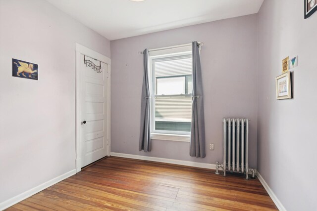 empty room with radiator heating unit and light wood-type flooring