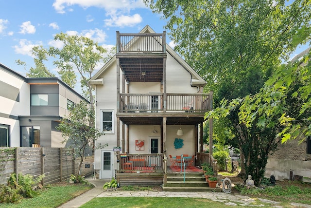 back of house featuring a porch and a balcony