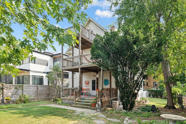 view of front facade with a balcony and a front yard