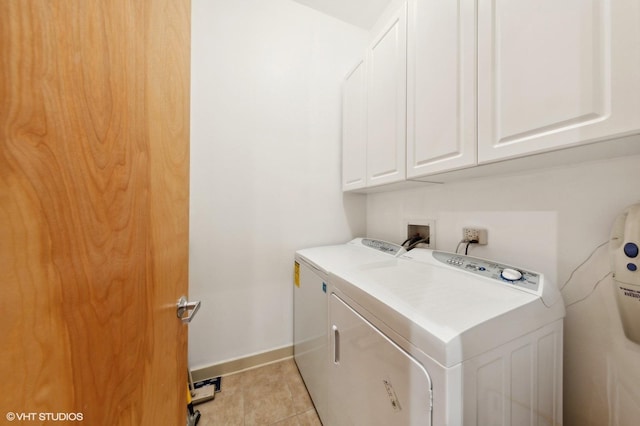 laundry area featuring cabinets, light tile patterned floors, and washing machine and dryer