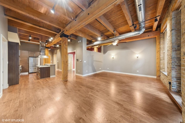 unfurnished living room featuring beam ceiling, ceiling fan, track lighting, wood ceiling, and light wood-type flooring