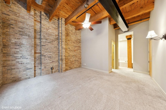 carpeted spare room with ceiling fan, a towering ceiling, beamed ceiling, and wood ceiling