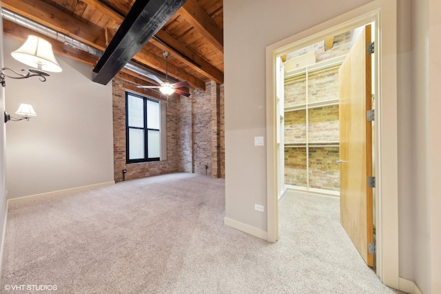 unfurnished room featuring brick wall, wood ceiling, light colored carpet, ceiling fan, and beamed ceiling