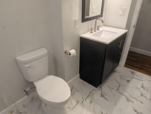 bathroom featuring toilet, marble finish floor, and baseboards