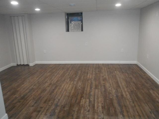 finished basement with dark wood-type flooring, recessed lighting, and baseboards