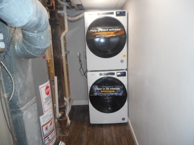 laundry area with gas water heater, laundry area, wood finished floors, baseboards, and stacked washing maching and dryer