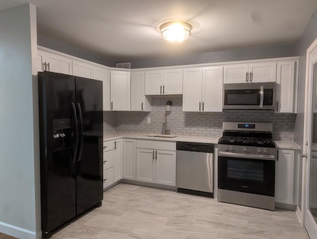 kitchen featuring stainless steel appliances, a sink, visible vents, light countertops, and decorative backsplash