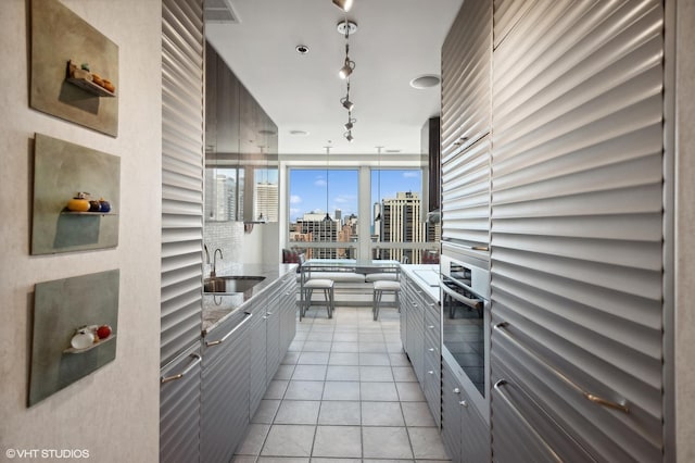 kitchen featuring light tile patterned flooring, sink, and stainless steel oven