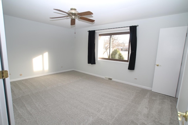 carpeted spare room with ceiling fan