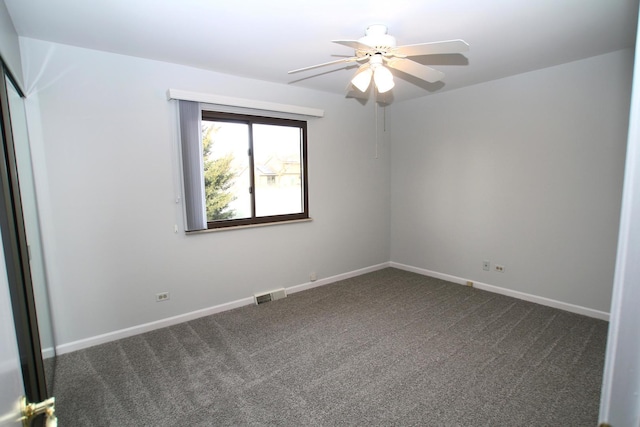 empty room featuring dark colored carpet and ceiling fan