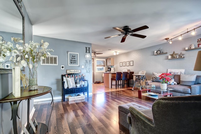 living room with wood-type flooring, ceiling fan, and brick wall