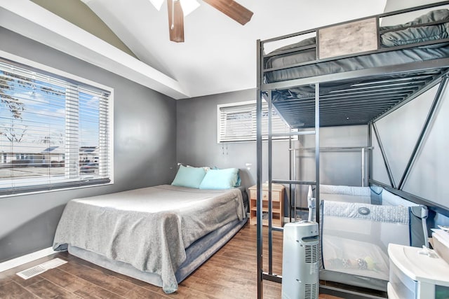 bedroom with dark hardwood / wood-style floors, vaulted ceiling, and ceiling fan