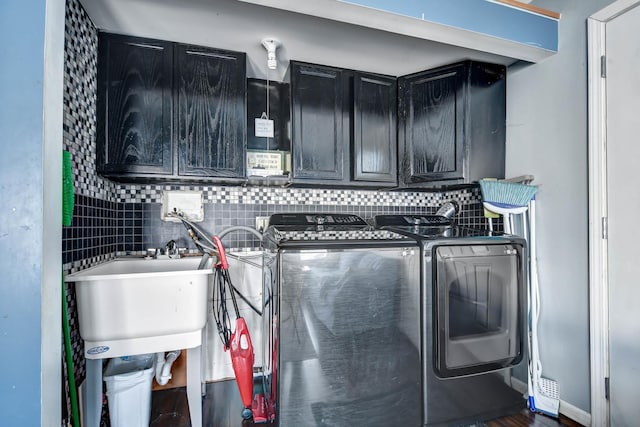 laundry room featuring cabinets, separate washer and dryer, and sink