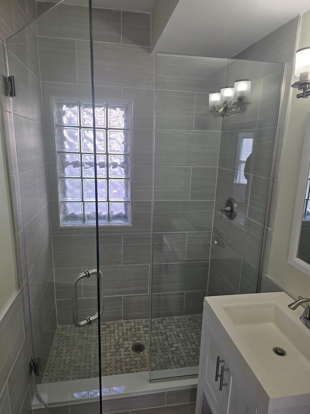 bathroom with a notable chandelier, vanity, and an enclosed shower