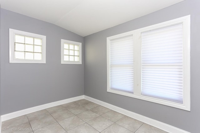 tiled spare room with lofted ceiling