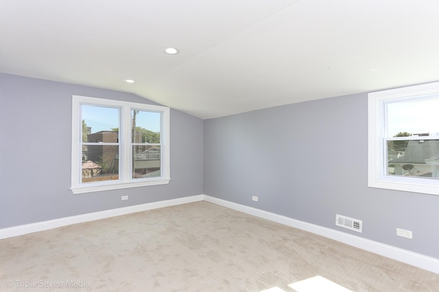 bonus room with light colored carpet and vaulted ceiling