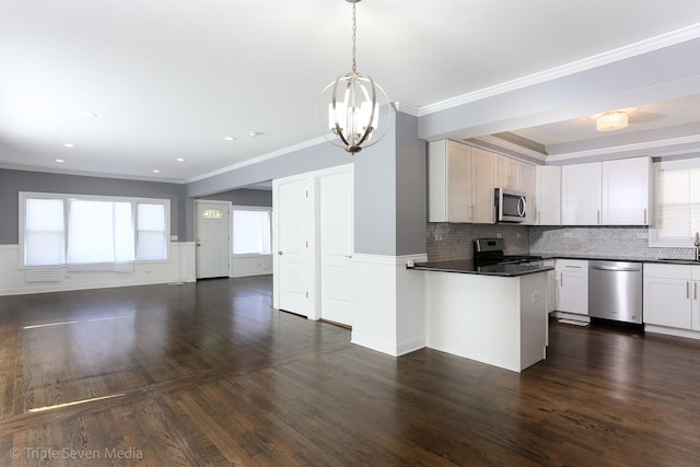 kitchen with decorative backsplash, appliances with stainless steel finishes, crown molding, decorative light fixtures, and white cabinetry