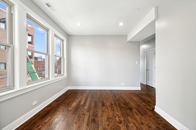 unfurnished room with dark wood-type flooring