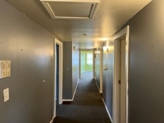 hall with dark colored carpet