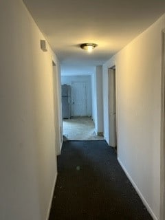 hallway with dark colored carpet