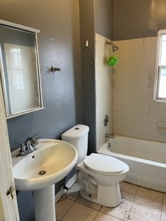 bathroom with tile patterned flooring, tiled shower / bath combo, and toilet