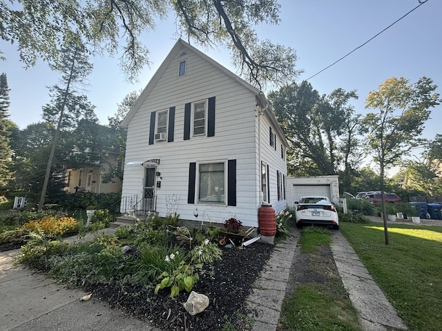 view of front of home featuring an outbuilding, a garage, and a front lawn