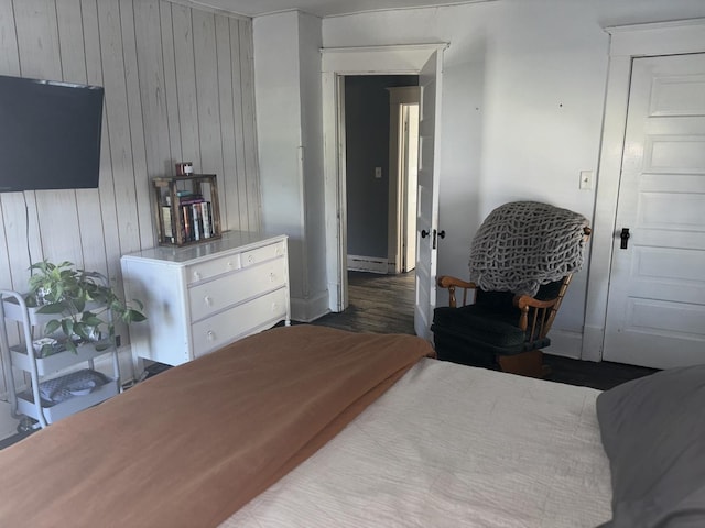 bedroom featuring a baseboard radiator and wood walls