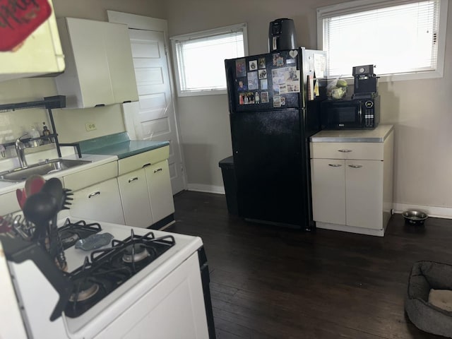 kitchen with white cabinets, sink, dark wood-type flooring, and black appliances