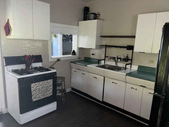 kitchen with black refrigerator, dark hardwood / wood-style flooring, white range with gas cooktop, sink, and white cabinets