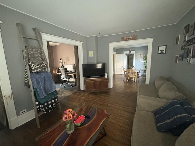 living room with dark hardwood / wood-style flooring and a notable chandelier