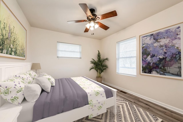 bedroom featuring multiple windows, ceiling fan, and dark hardwood / wood-style floors