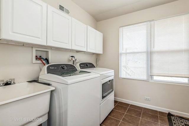 clothes washing area featuring cabinets, dark tile patterned floors, sink, and washing machine and dryer