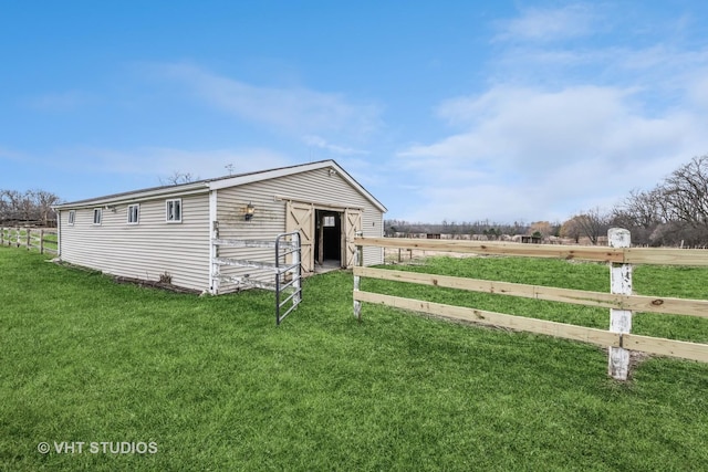 view of outbuilding featuring a lawn and a rural view