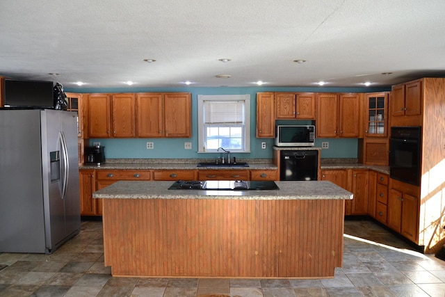 kitchen featuring sink, a textured ceiling, black appliances, and a kitchen island