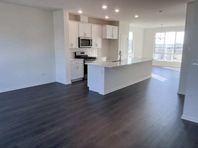 kitchen featuring appliances with stainless steel finishes, a center island with sink, white cabinetry, and sink