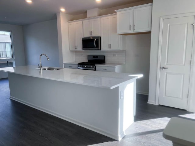 kitchen with a center island with sink, sink, white cabinetry, and stainless steel appliances