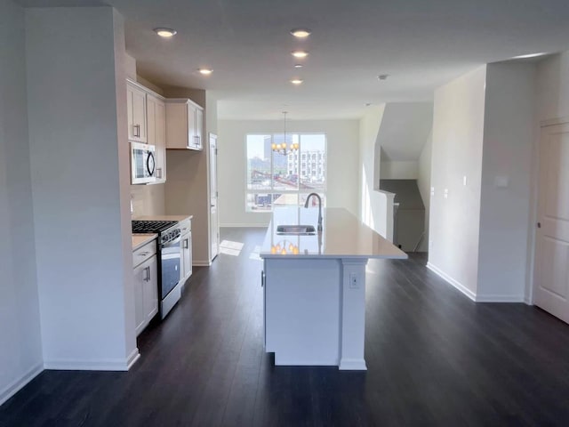 kitchen with sink, a center island with sink, a notable chandelier, white cabinets, and stainless steel range with gas cooktop