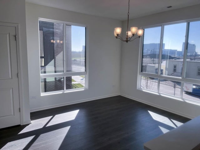 unfurnished dining area with dark hardwood / wood-style flooring and a notable chandelier