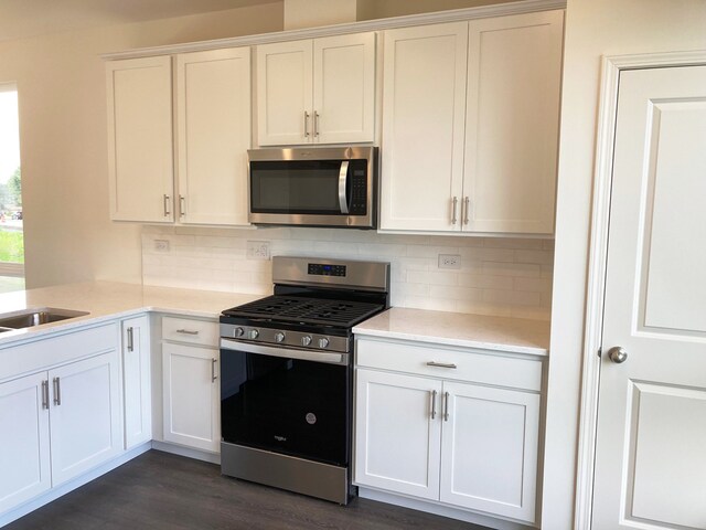 kitchen featuring tasteful backsplash, white cabinets, and stainless steel appliances