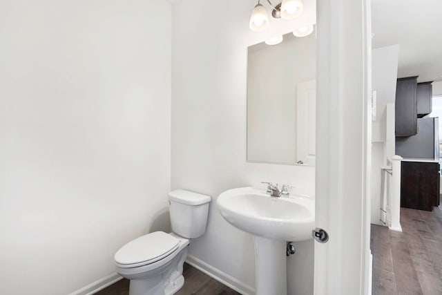 bathroom with a chandelier, wood-type flooring, and toilet